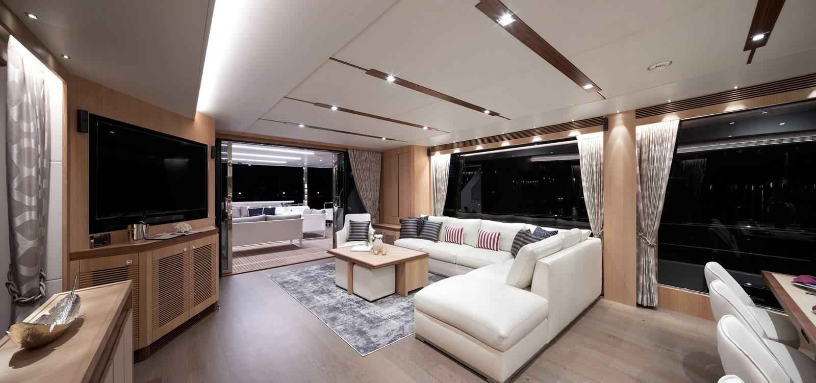 FD87 Aqua Life Salon aft view with sofa, coffee table, TV and doors to aft deck.
