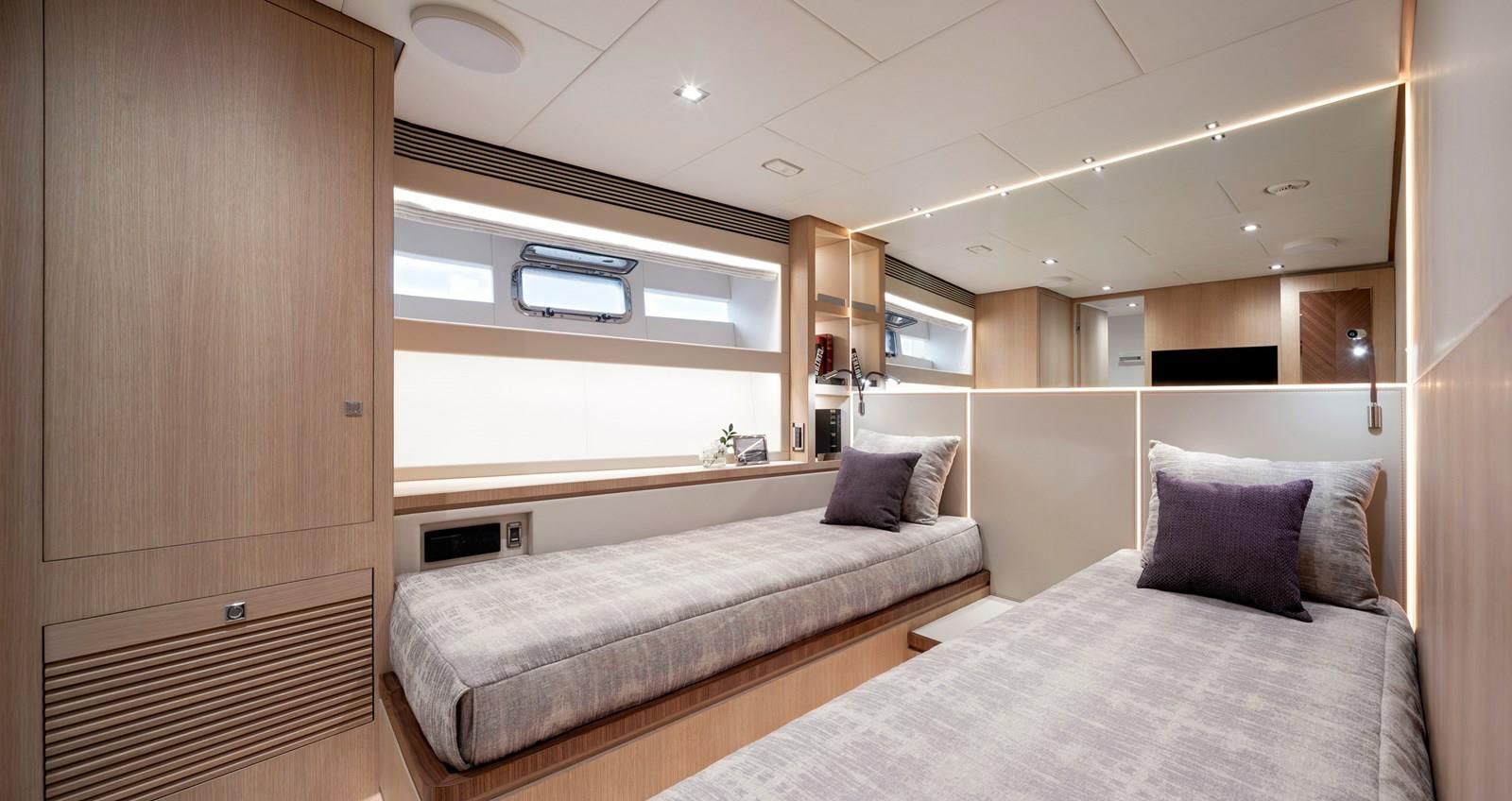 FD87 Aqua Life guest stateroom with twin beds and nightstand.