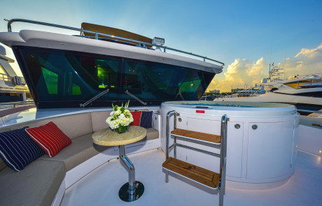 Yacht Freedom Horizon FD92 | Siting area with table and hot tub